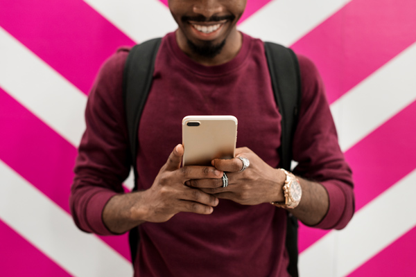 Homem segurando um smartphone e sorrindo.