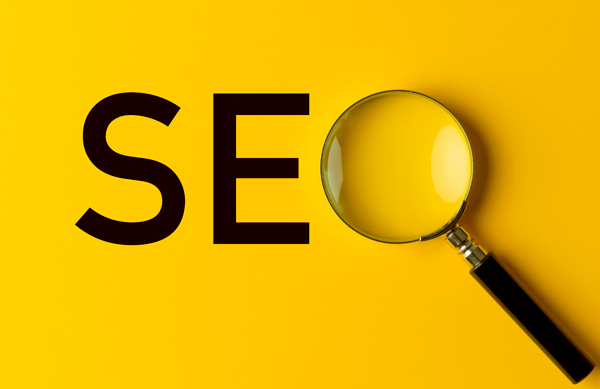 Imagem com a sigla SEO num fundo amarelo, no lugar do O tem uma lupa.