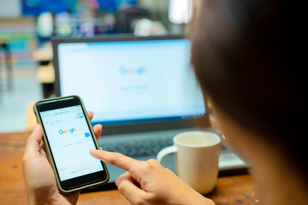 Mulher fazendo pesquisa no Google pelo celular.