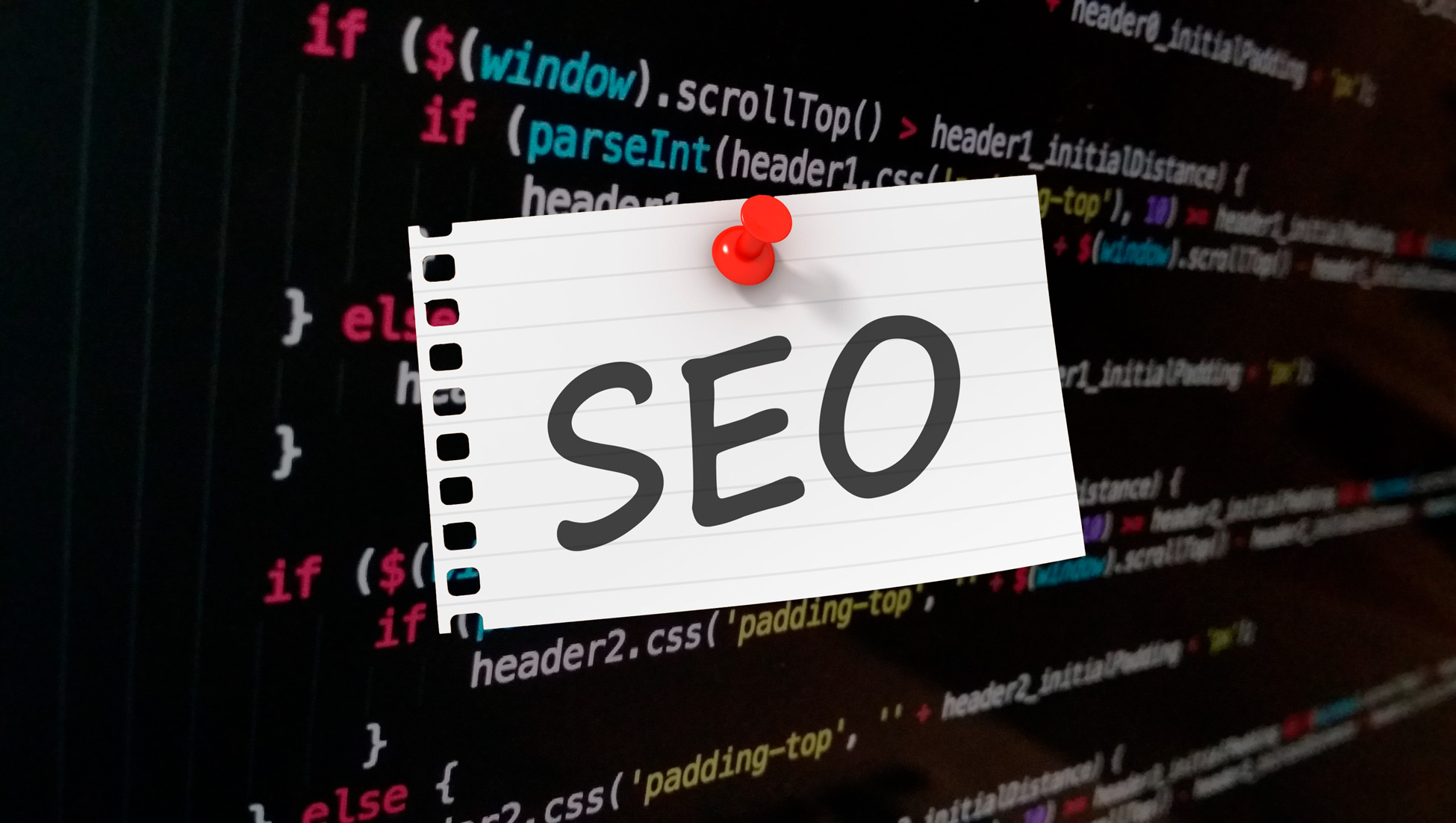 SEO escrito em folha de papel em frente a uma tela com códigos, indicando trabalho da agência de SEO.