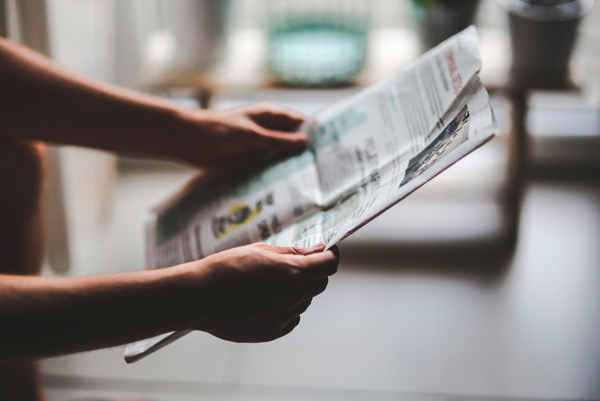 Pessoa segurando um jornal, marketing tradicional
