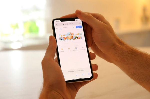 Pessoa segurando celular com Google aberto, representando a experiência do usuário.