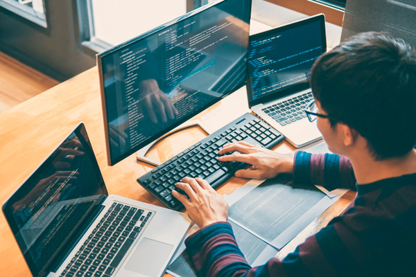Pessoa trabalhando com programação web em notebook.