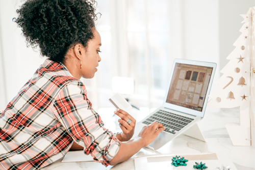Mulher usando notebook para fazer compras online.