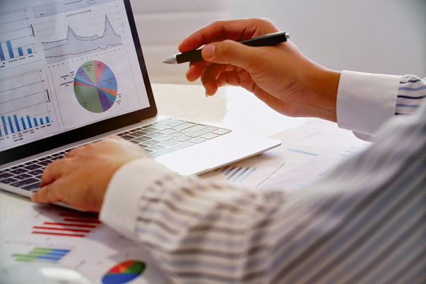 Profissional de SEO fazendo análise de gráficos em computador.