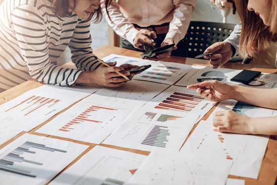 Pessoas analisando gráficos com resultados de SEO local Google.