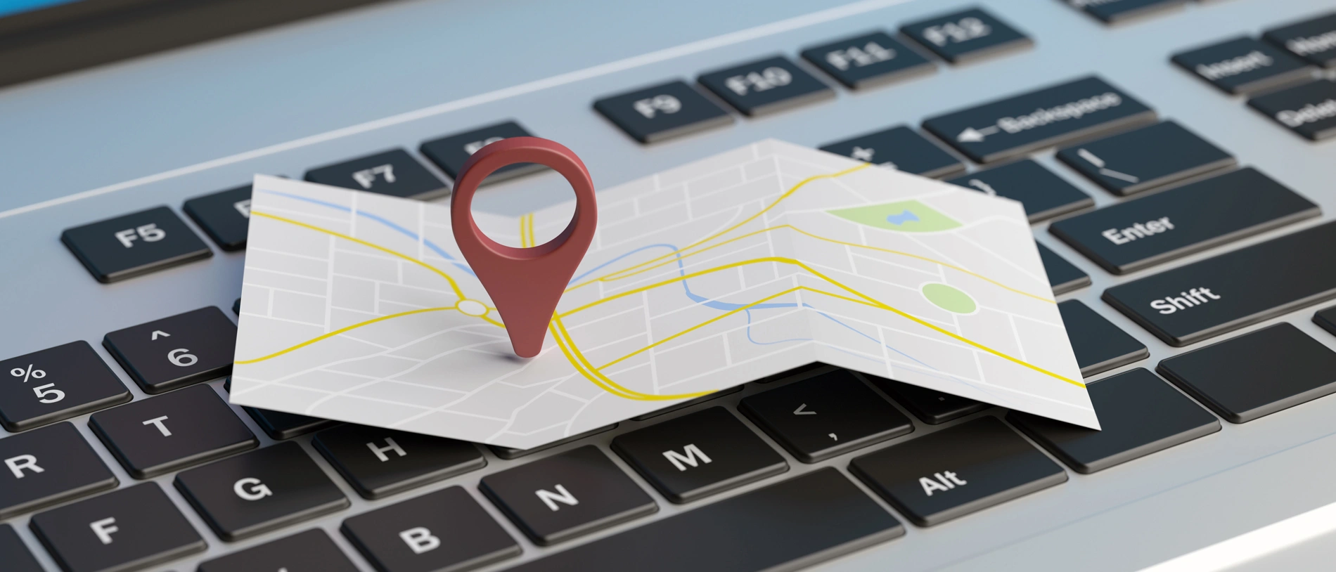 Imagem 3D de mapa com indicador em cima de teclado, representando SEO local.