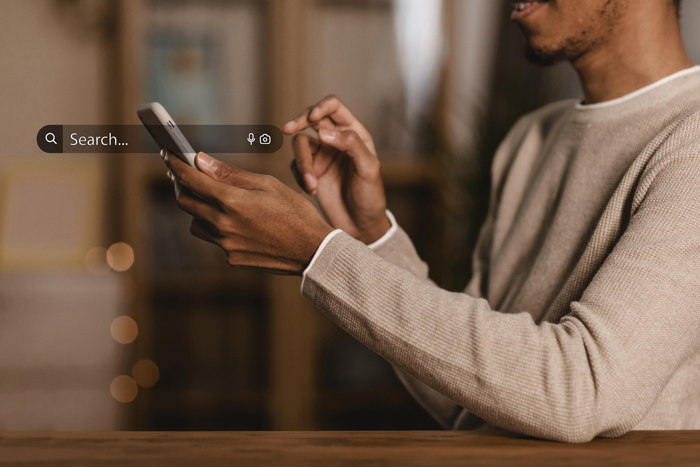 Homem usando smartphone com barra de busca em destaque, representando pesquisas em tempo real e estratégias de SEO conversacional.
