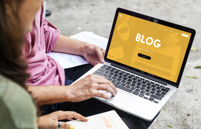 Duas pessoas trabalhando em um blog no laptop, organizando pautas e conteúdos evergreen dentro de um calendário de conteúdo.