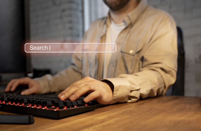 Profissional digitando em computador com barra de busca visível, ilustrando práticas de seo off page como construção de autoridade, presença digital e influência fora do site.
