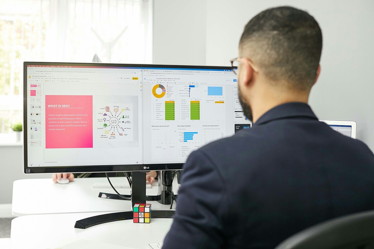 Profissional analisando dados de inside sales e SEO em painéis de lead scoring, funil de marketing e desempenho de conteúdo em tela dupla.